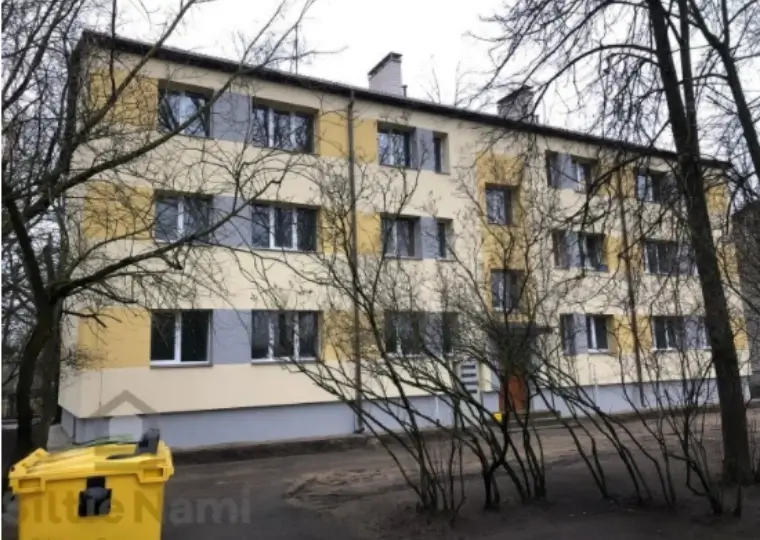 Отремонтированный трёхэтажный многоквартирный дом с бежевым и серым фасадом