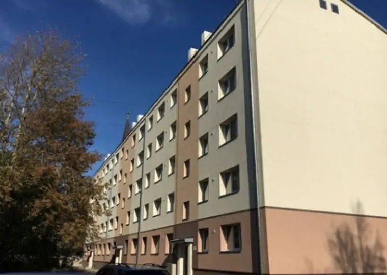 Renovated apartment building with a light facade in grey and brown tones