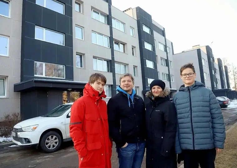 Жители у отремонтированного многоквартирного дома с тёмной и светлой отделкой фасада