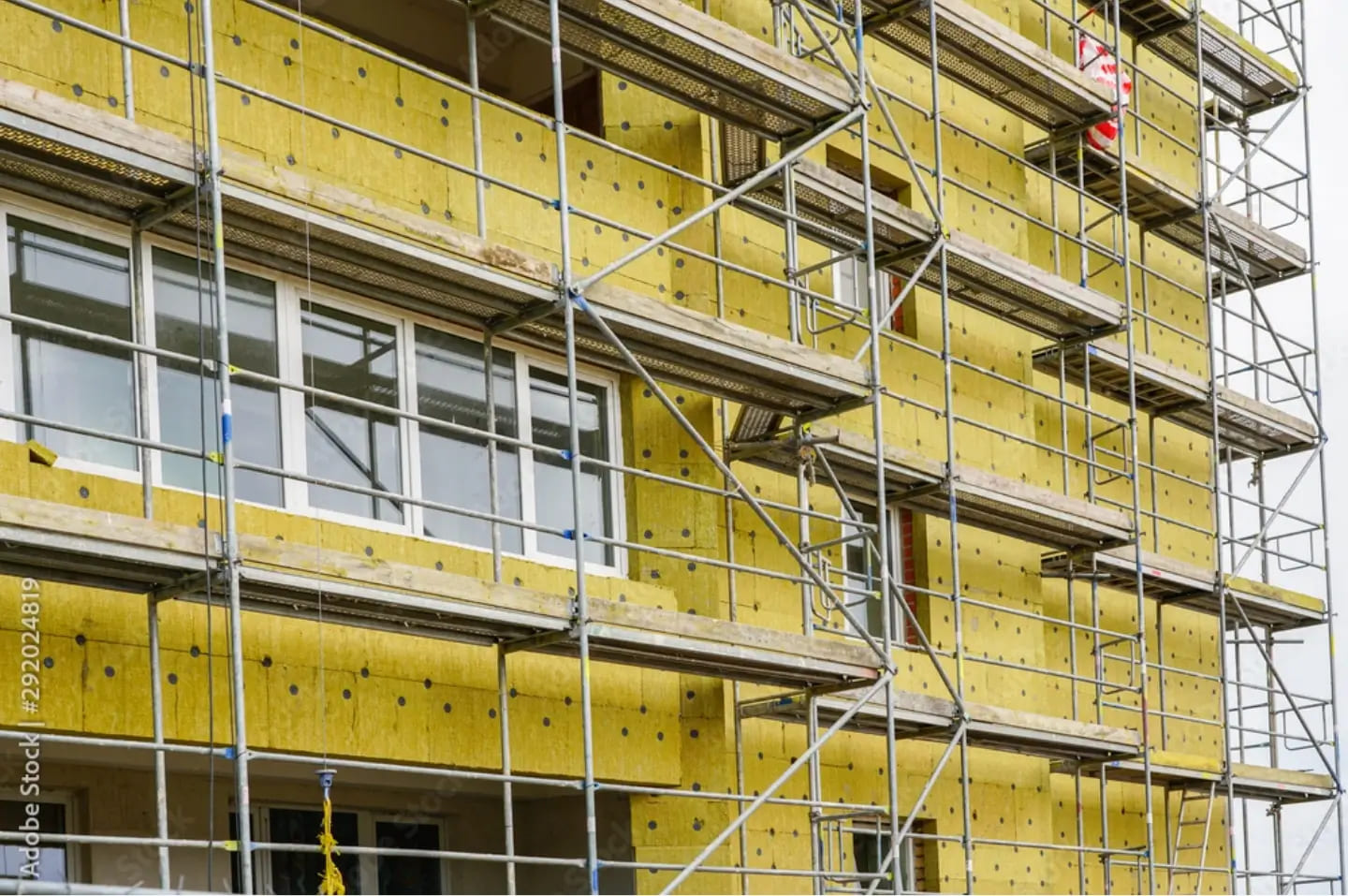 Building facade insulation with mineral wool on a metal frame during construction work.