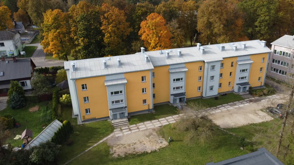 4 stāvu daudzdzīvokļu ēka ar dzeltenu fasādes apdari, pelēku skārda jumtu, Valka