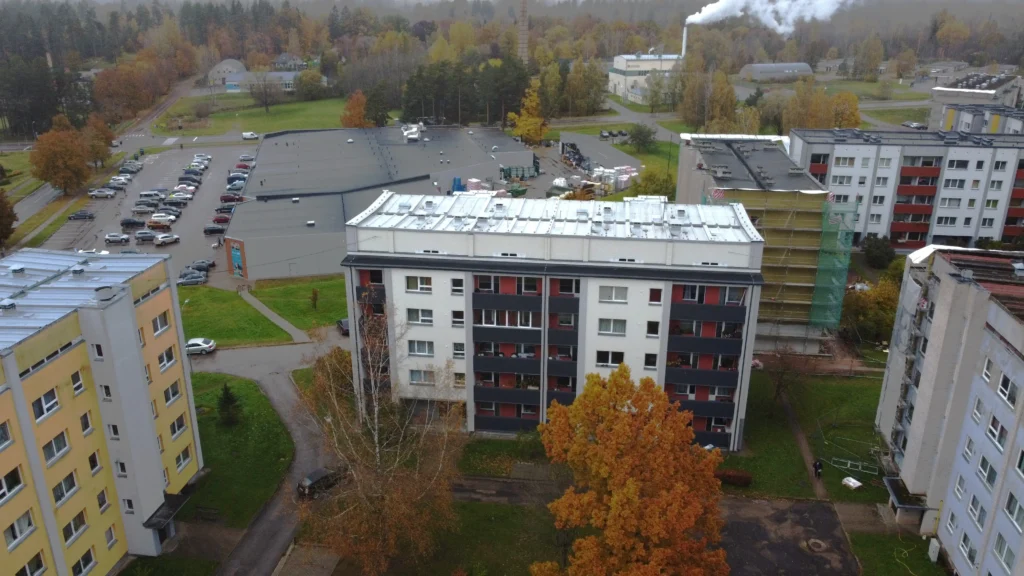 Apartment building with a white facade finish, dark balconies and a metal roof, Valka