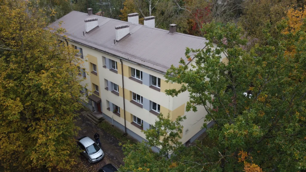 Trīsstāvu daudzdzīvokļu ēka ar krēmkrāsas fasādes apdari un pelēku metāla jumtu, Rīga