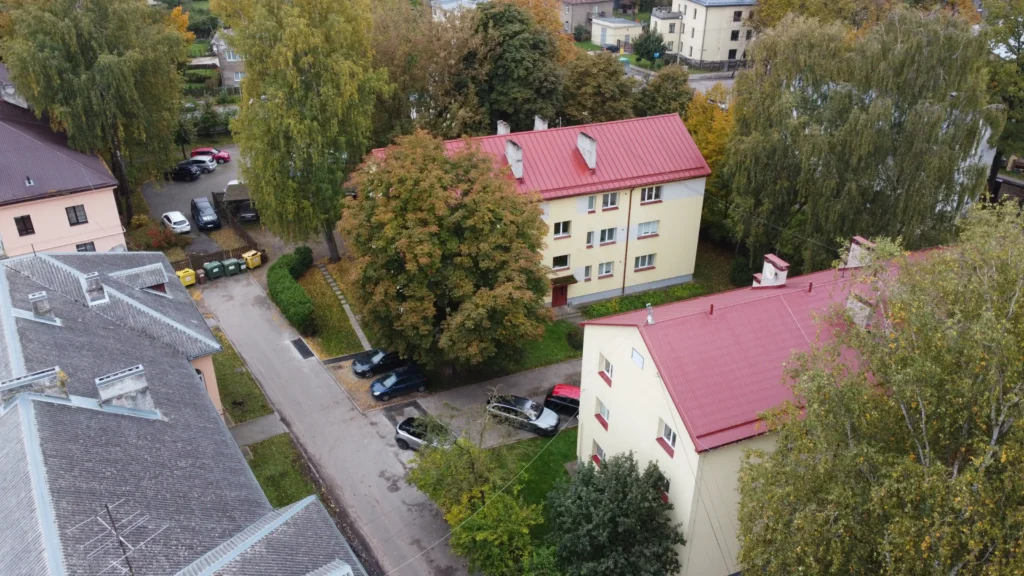 Divas daudzdzīvokļu ēkas ar gaišu fasādi un sarkaniem jumtiem, drona skats, Rīga