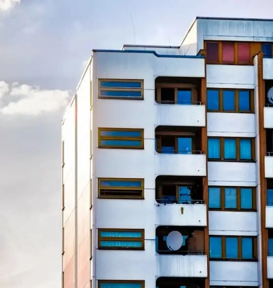 Apartment building facade detail with balconies and windows, side view